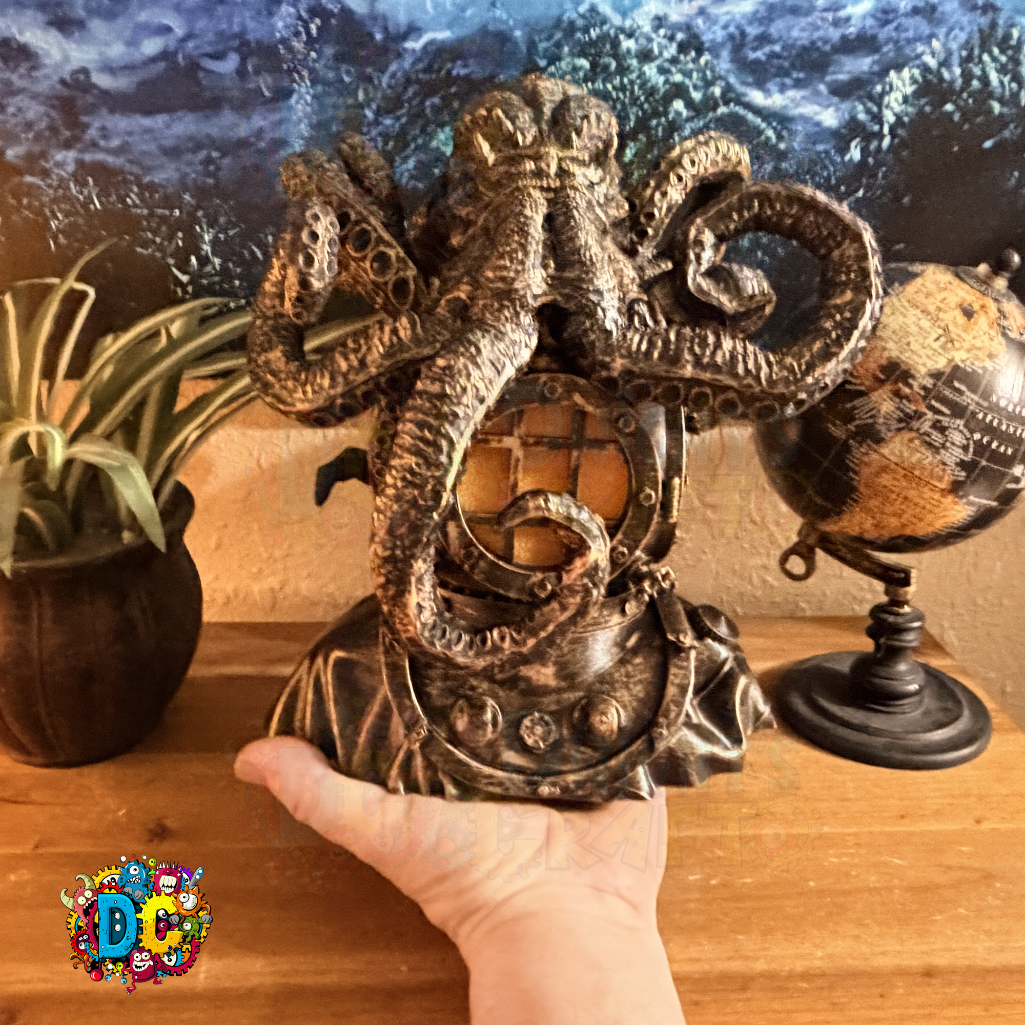 Decorative octopus lamp held by a hand on a wooden surface with a globe and plant in the background.