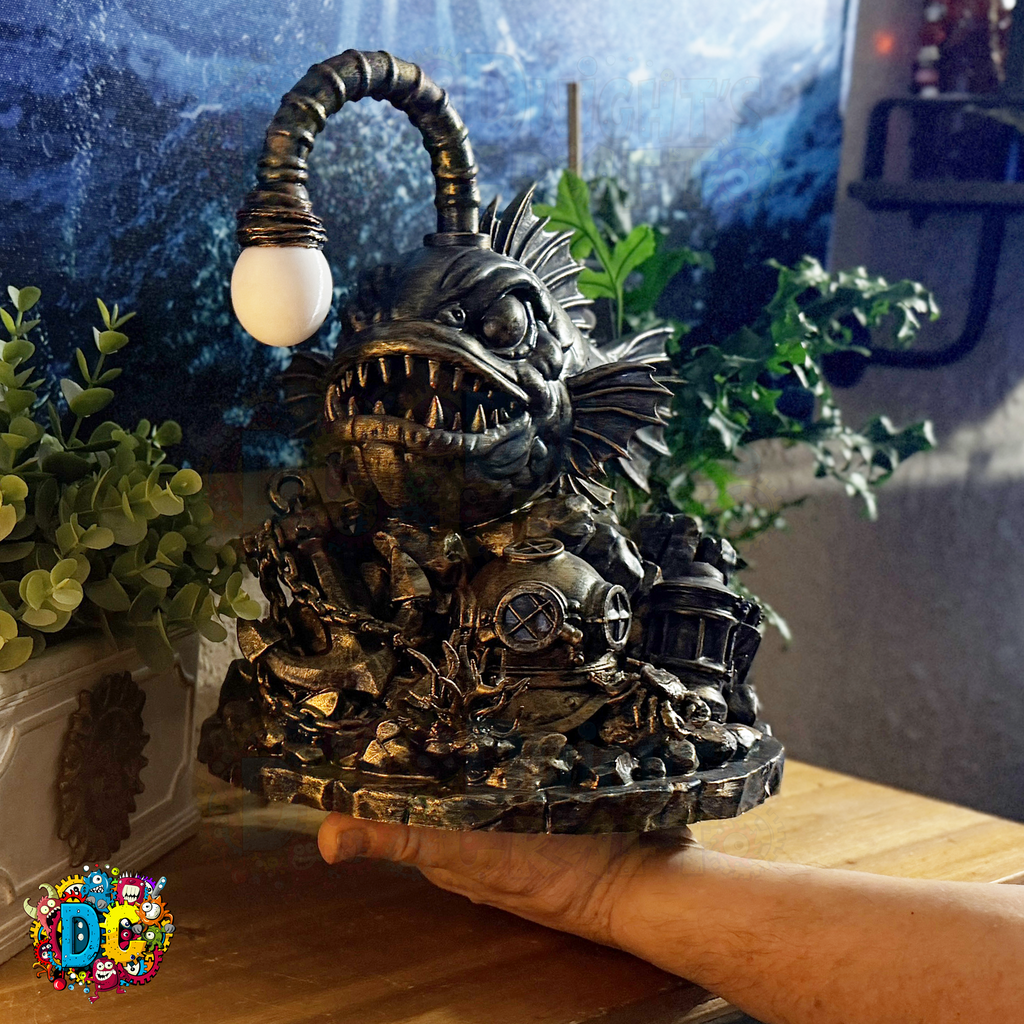 Decorative angler fish-shaped ambient light on its lure, held by a hand in a room with plants and a window.