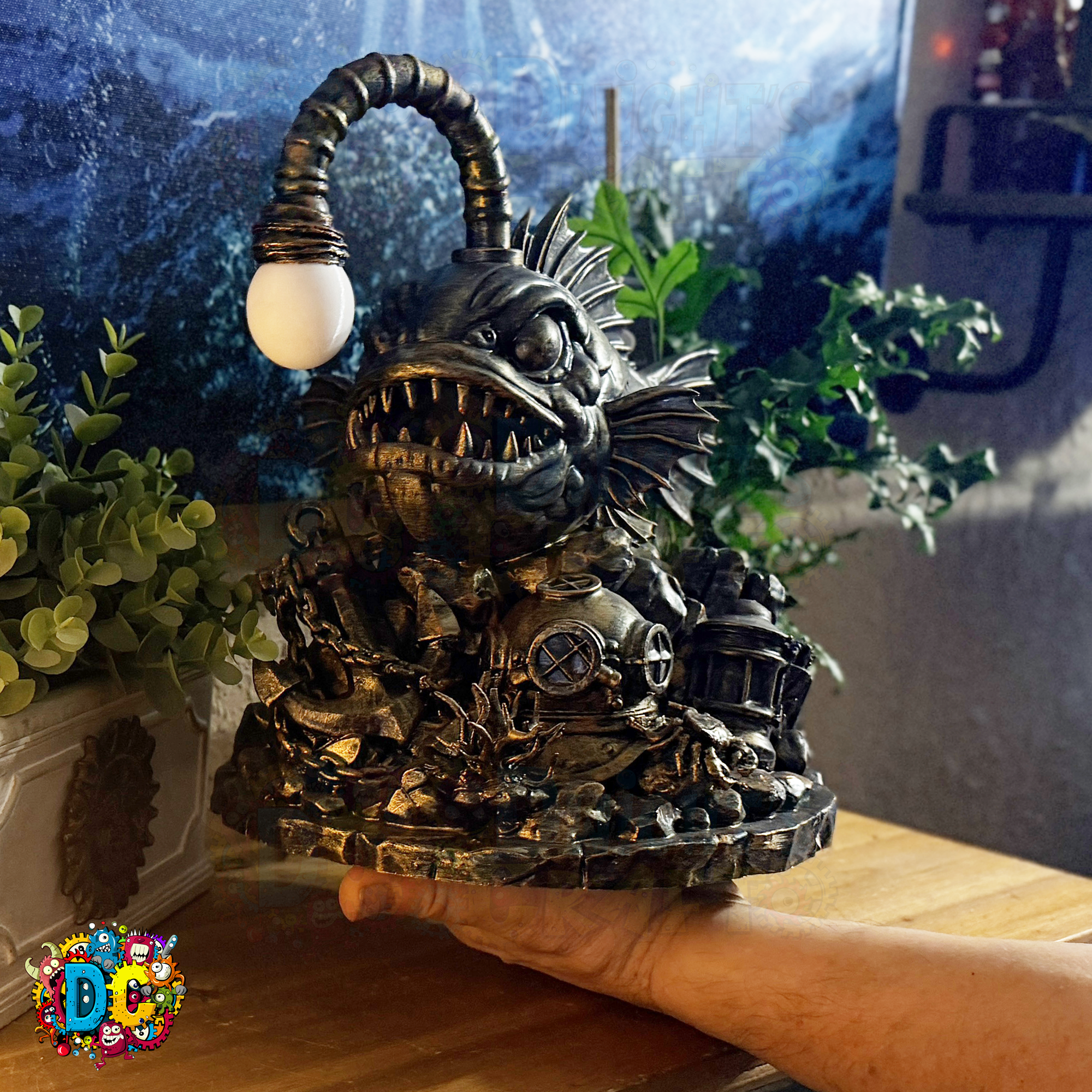 Decorative angler fish-shaped ambient light on its lure, held by a hand in a room with plants and a window.