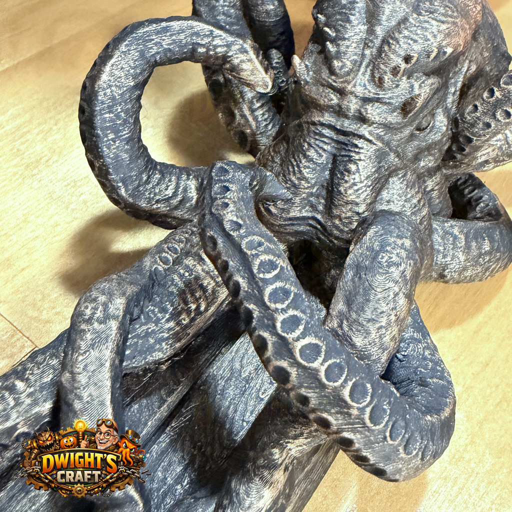 A detailed close-up of a gray and black textured octopus sculpture with suction cups, resting on a light wood surface. A 'Dwight's Craft' logo is visible in the bottom-left corner.