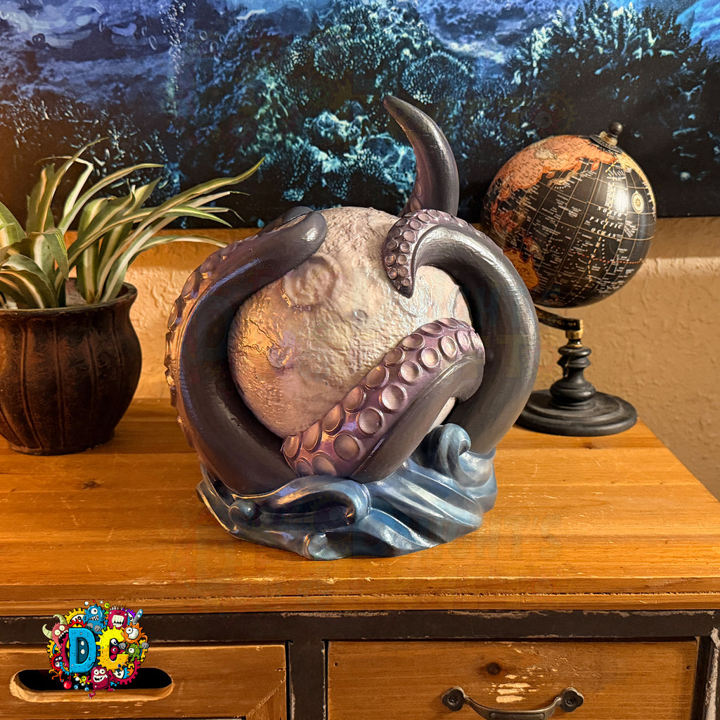 Decorative octopus sculpture on a wooden surface with a globe and plant in the background