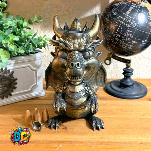 Decorative dragon statue on a wooden surface with a globe and plant in the background
